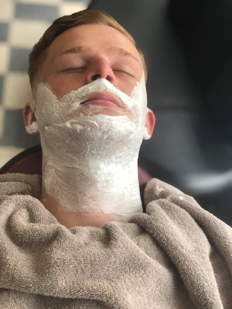 Hot towel wet shave with cream across the jaw and neck
