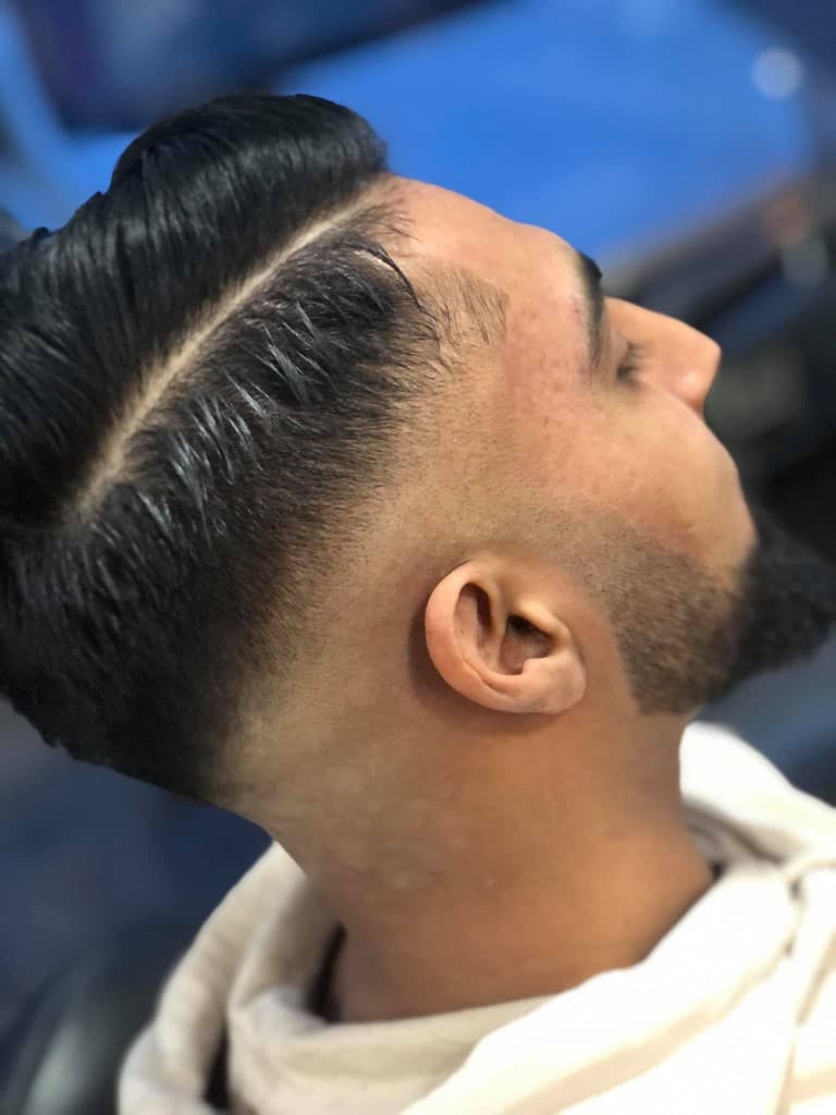 Side-part skin fade with a sharp beard connection